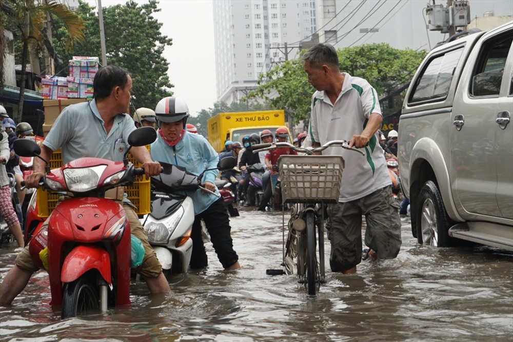 Nhiều người dân phải bì bõm trong dòng nước hôi thối để đi học, đi làm.