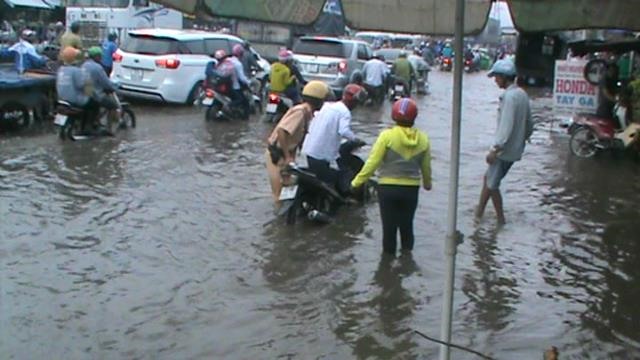 Trong mênh mông nước, nhiều người không biết phải dắt xe vào chỗ nào, nhưng rất may là đã có những anh CSGT sẵn sàng hỗ trợ. Ảnh: T.S