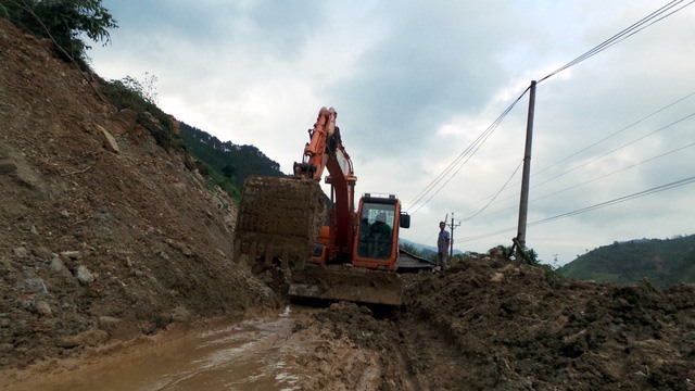 Có những đoạn, khi xe vừa đi qua, đất đá tiếp tục sạt lở, bịt kín đường. Máy xúc luôn túc trực để làm nhiệm vụ.