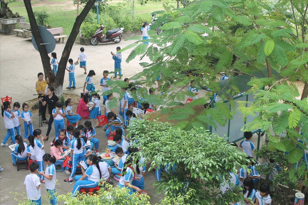 Giờ ra chơi, các em học sinh ùa ra thư viện lưu động để đọc sách. Ảnh: T.H