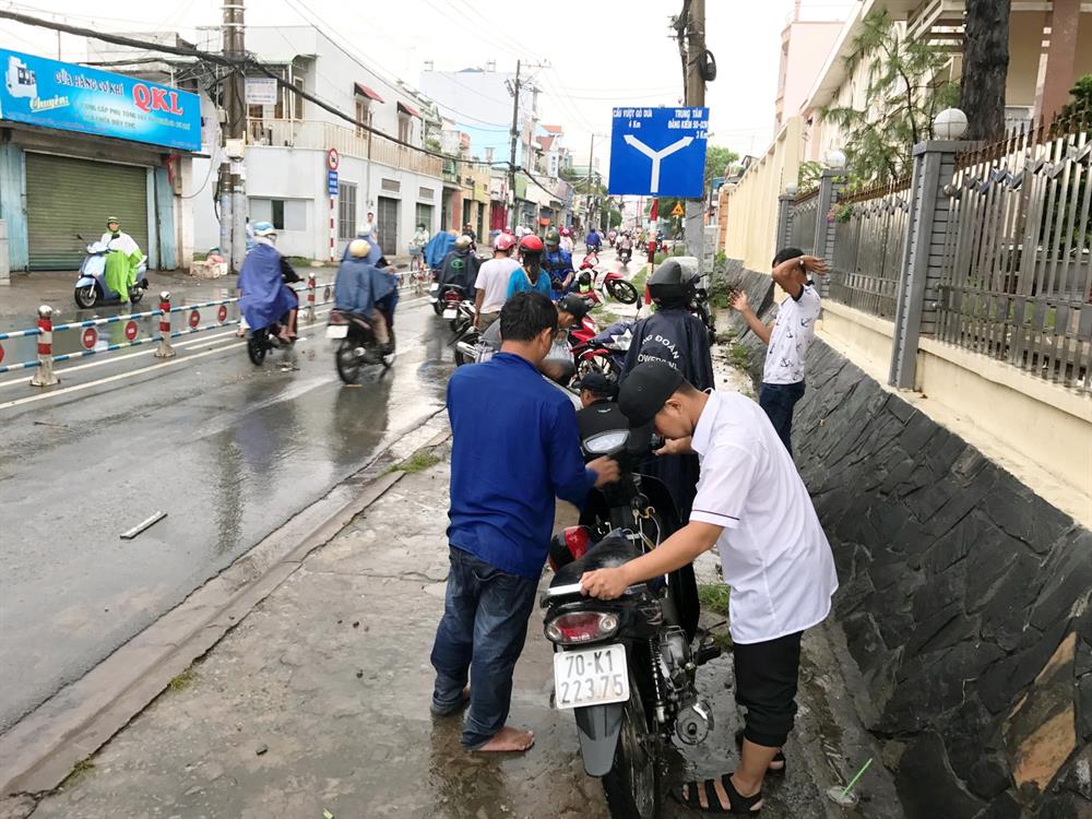 Nhiều người dân phải loay hoay sửa xe chết máy. Ảnh: M.Q