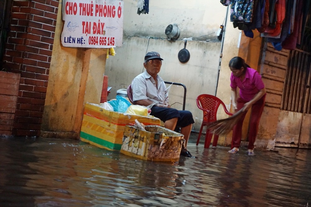 Nước ngập ảnh hưởng đến sinh hoạt và buôn bán của người dân trên đường Nguyễn Tất Thành (Q.4). Ảnh: M.Q