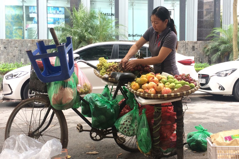 Một phụ nữ đang bán hàng rong trên địa bàn quận Cầu Giấy, Hà Nội. Ảnh: QUẾ CHI
