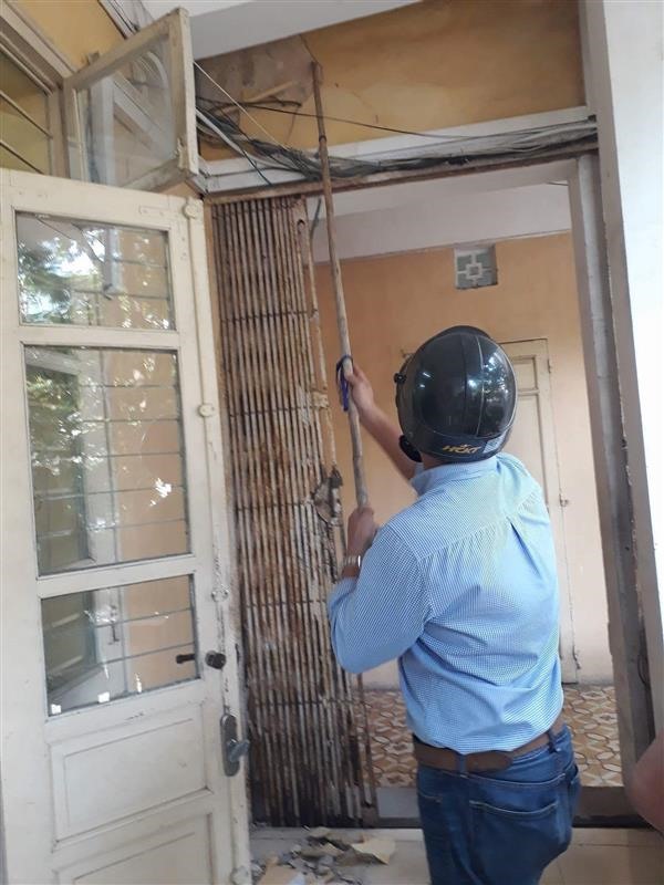 Khi học sinh nghỉ học, các thầy cô Trường THPT Trần Nhân Tông cầm sào để chọc lên trần và tường lớp cho các mảng vữa bở rơi xuống sàn nhà nhằm tránh bị rơi bất ngờ gây tai nạn. Ảnh: ĐH
