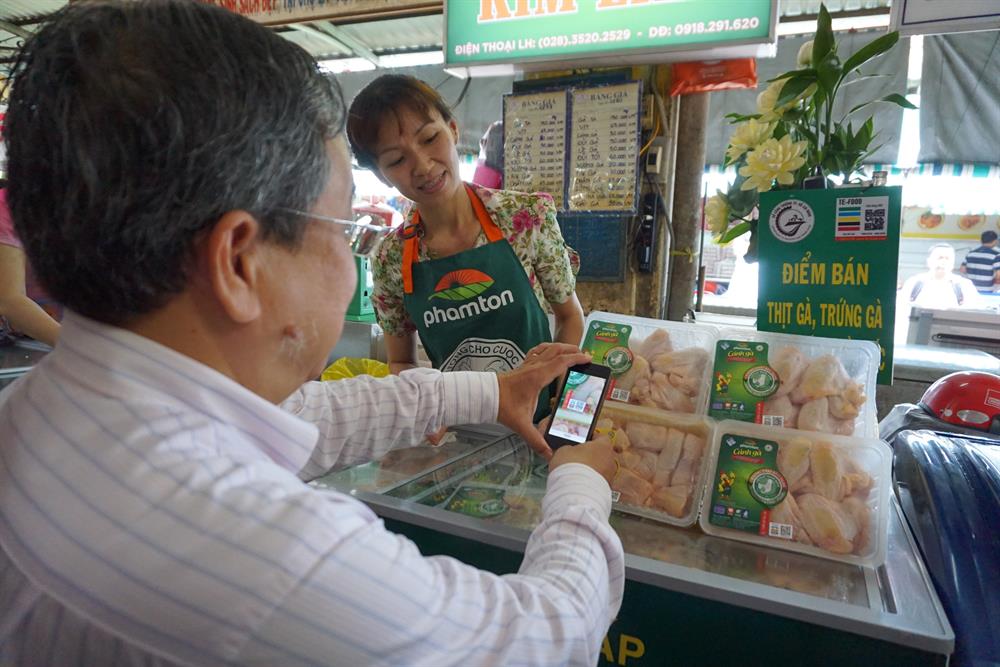 Để truy xuất nguồn gốc, người tiêu dùng sử dụng điện thoại thông minh có cài phần mềm Te-food để soi vào con tem được dán trên vỉ trứng và thịt gà. Ảnh: M.Q