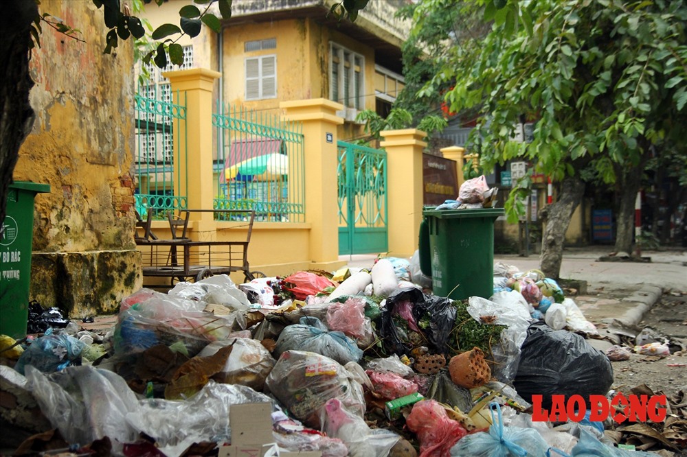 Rác thải không được xử lý, ngày một nhiều, chất thành núi cạnh vườn hoa, cổng trường học, bệnh viện, trụ sở phường...