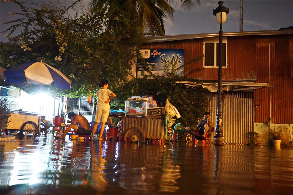 Mọi sinh hoạt của người dân nơi đây từ ăn uống đến đi buôn bán đều bì bõm trong nước ngập. Ảnh: M.Q