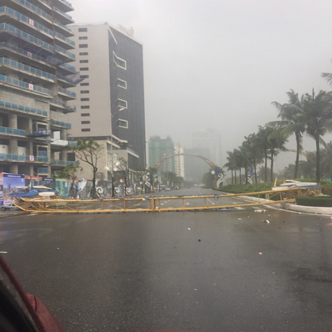 Dù cách xa tâm bão khoảng 500km, gió lớn vẫn đủ sức giật đổ cổng chào ở ngã tư Võ Nguyên Giáp - Phạm Văn Đồng (Đà Nẵng), một số banner dựng trên đường cũng bị gió quật ngã. (Ảnh: Cảnh Toàn)