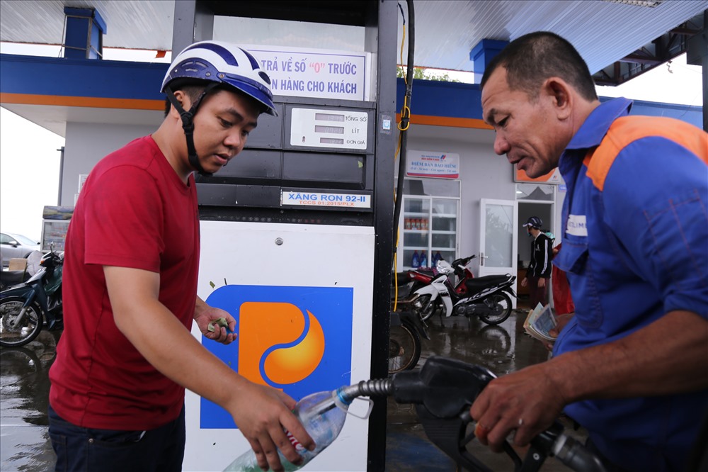 Mất điện, nhiều cây xăng tại huyện Vạn Ninh dùng máy phát điện để phục vụ nhu xăng dầu cho người dân trên địa bàn. Trong ảnh là một người dân mua xăng dầu tích trữ.