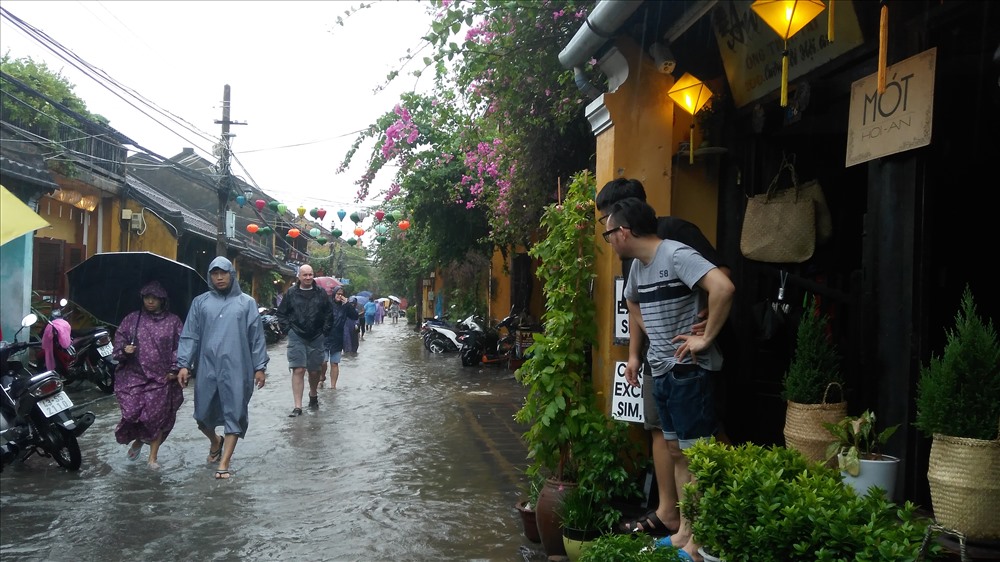 Đội mưa và lội nước ở Hội An dịp này là một trải nghiệm thú vị. Ảnh: H.V.M