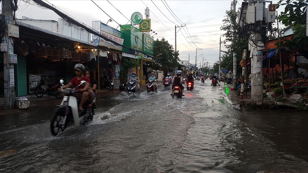 Cách đường Huỳnh Tấn Phát khoảng 2km là đường Lê Văn Lương - nơi được mệnh danh là “rốn ngập” không chỉ của huyện Nhà Bè mà của cả TPHCM. Mỗi khi triều cường dâng, con đường dài chừng 6km này trong chừng vài chục phút đã biến thành một dòng sông. Ảnh: Trường Sơn
