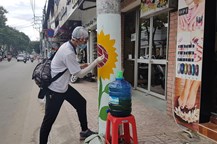 Các bạn sinh viên đang vẽ hoa hướng dương lên các trụ điện trên đường Lê Văn Sỹ (phường 1, quận Tân Bình). Ảnh: Trường Sơn