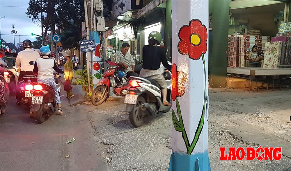 Không chỉ vẽ trên các trụ điện trung, hạ thế, các cột đèn giao thông cũng được điểm tô bằng những bông hoa xinh đẹp. Ảnh: Trường Sơn