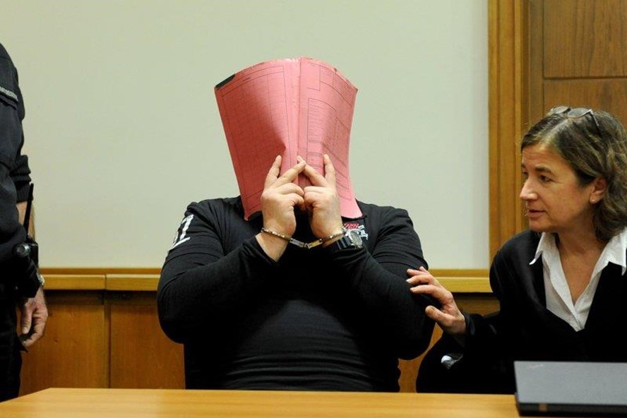 NNiels Högel che mặt, bên cạnh là luật sư của hắn tại tòa án ở Đức năm 2014. Ảnh: AFP/Getty
