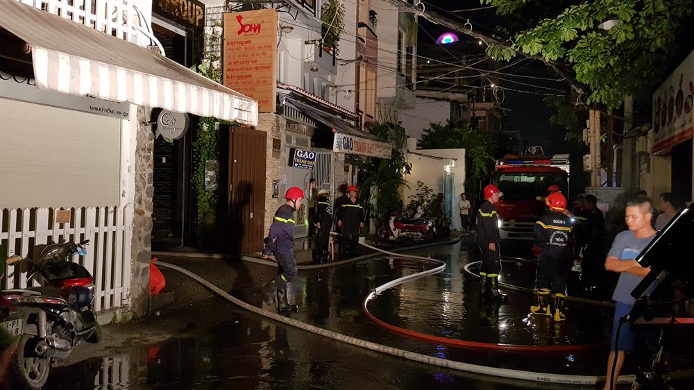 Cảnh sát tiếp tục phun nước dập lửa tàn. Ảnh: Trường Sơn