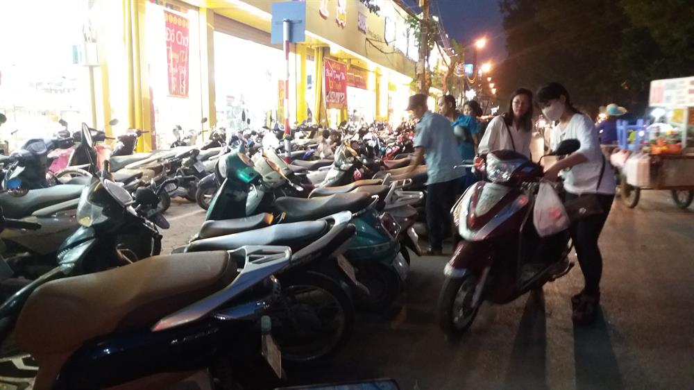 Rất nhiều chiếc xe máy để tràn xuống cả lòng đường trước cửa Nhà sách Tiến Thọ trên đường Láng.
