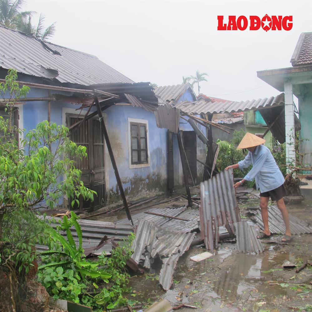 Ông Lê Viết Bờ, tổ 11, phường Thủy Dương lượm nhặt những tấm tôn còn lại để sửa căn nhà của mình. Ảnh: NĐT