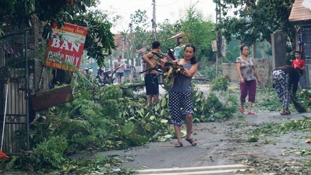 Bà con dọn dẹp, vì cây cối đổ rất nhiều. Ảnh: QĐ