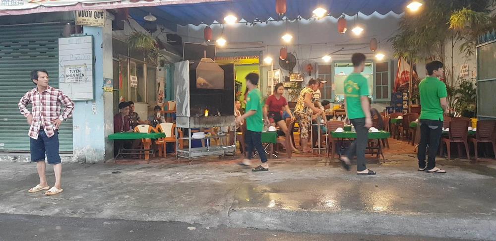 Nhân viên quán nhậu số 488 aVox Văn Kiệt tất tả dọn dẹp khi đoàn công tác đi ngang qua.