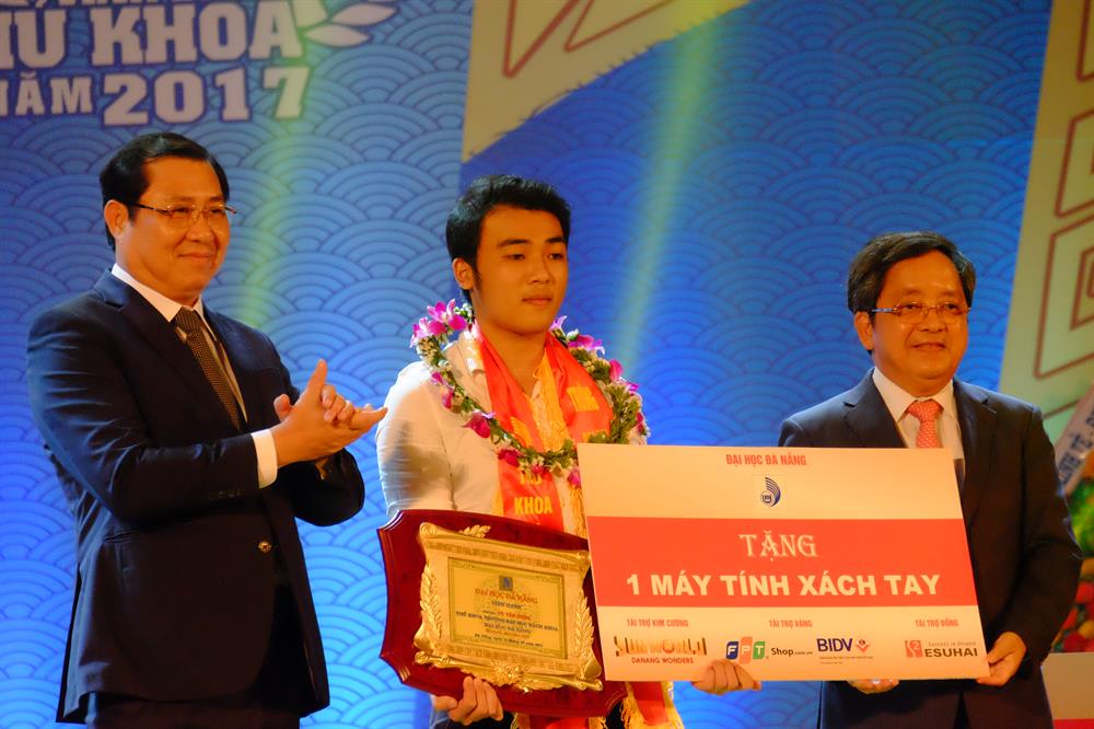 Chủ tịch UBND TP.Đà Nẵng cùng với Giám đốc Đại học Đà Nẵng tiến hành trao quà lưu niệm và phần quà khen thưởng vinh danh các tân thủ khoa. Ảnh: ML