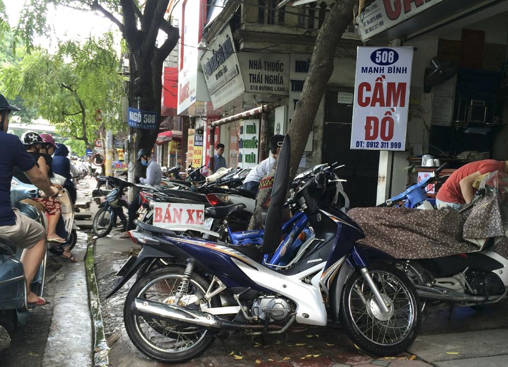 Hàng loạt xe máy trước các cửa hàng chắn hết các lối đi trên vỉa hè.