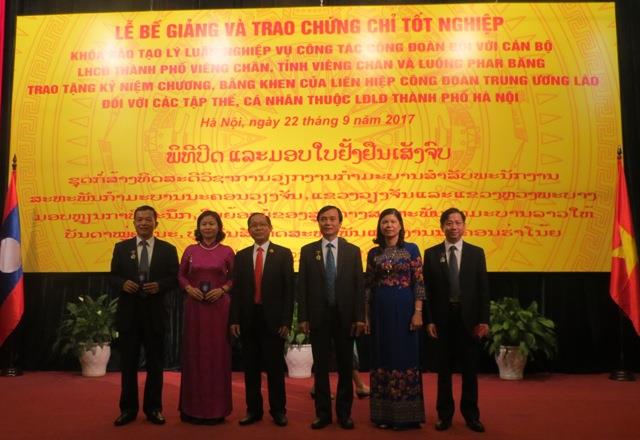 Đồng chí Kèn Khăm Hốt Thị Lạt - Ủy viên BCH LHCĐTƯ Lào, Chủ tịch LHCĐ TP. Viêng Chăn trao Kỷ niệm chương của LHCĐTƯ Lào cho 5 cá nhân là lãnh đạo LĐLĐ TP. Hà Nội. Ảnh: Xuân Trường