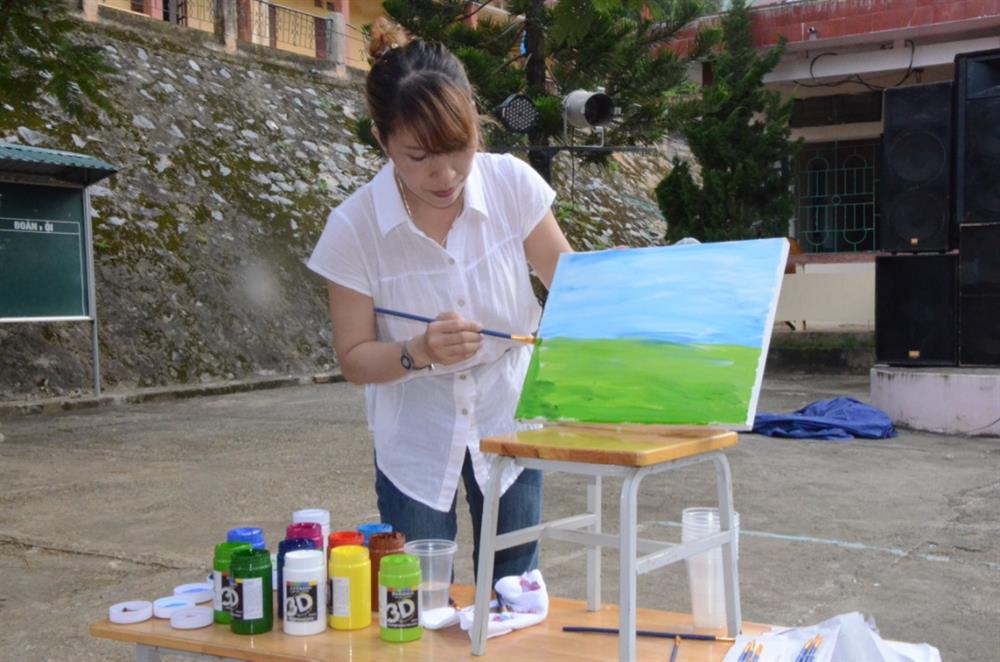 Học sĩ Trịnh Huyền hướng dẫn học sinh vẽ tranh trên vải. Ảnh: HH
