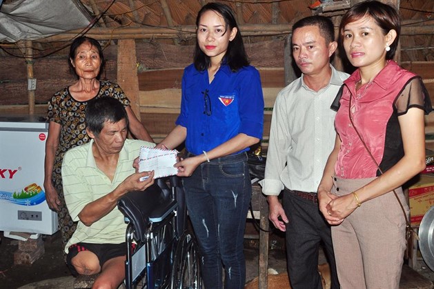 Hai chị em Thảo Thương tặng xe lăn và quà của nhà tài trợ cho ông Phan Xuân Trường. Ảnh: Minh Lý