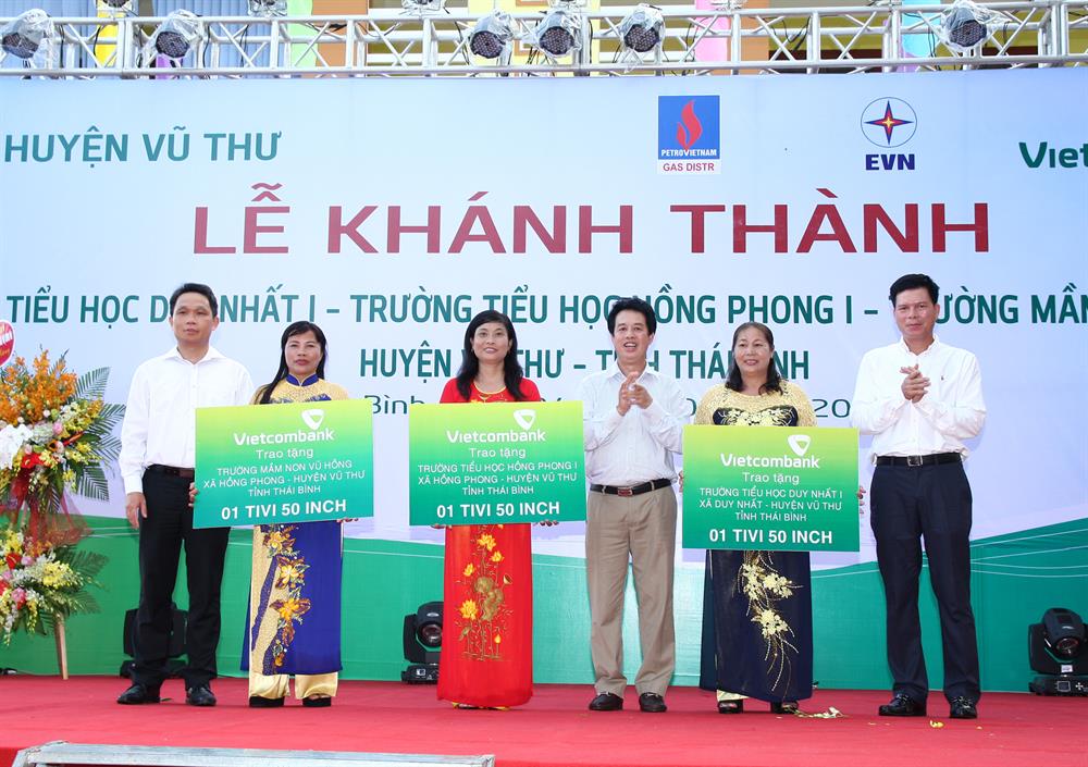 Ông Nguyễn Mạnh Hùng - Ủy viên HĐQT Vietcombank (ngoài cùng bên trái) cùng Ông Nguyễn Mỹ Hào - Ủy viên HĐQT Vietcombank (thứ 3 từ phải sang) và Ông Phạm Mạnh Thắng – Phó Tổng giám đốc Vietcombank (ngoài cùng bên phải) trao tặng thiết bị là ti vi 50 inch cho 3 trường học: Trường Tiểu học Duy Nhất 1, Trường Tiểu học Hồng Phong 1 và Trường mầm non Vũ Hồng (Huyện Vũ Thư, tỉnh Thái Bình)