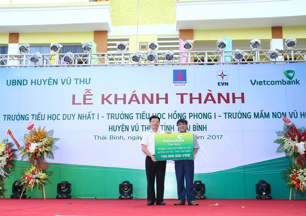 Ông Đào Minh Tuấn – Phó Tổng giám đốc, Chủ tịch Công đoàn Vietcombank (bên trái) trao số tiền 100 triệu đồng của Vietcombank tặng Trường THCS thị trấn Vũ Thư, huyện Vũ Thư, tỉnh Thái Bình