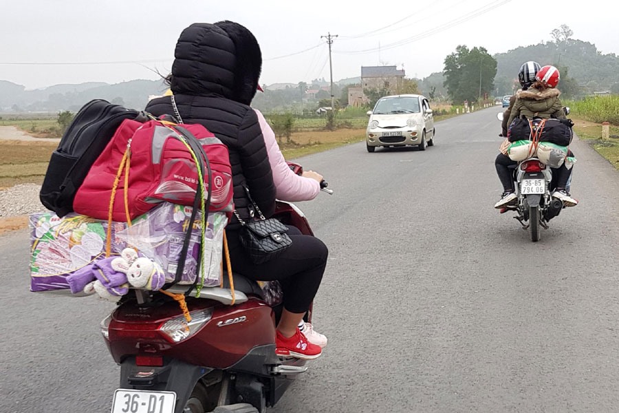  Người dân lỉnh kỉnh đồ đạc di chuyển bằng xe máy ra Hà Nội sau tết. Ảnh: P.V