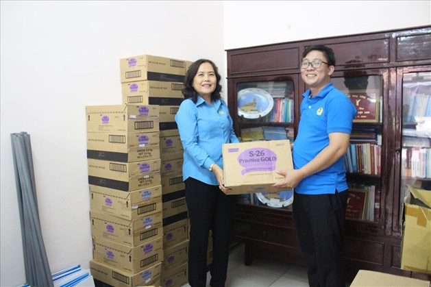 Chủ tịch LĐLĐ tỉnh Long An Lê Thị Rết tiếp nhận sữa từ đại diện Quỹ Tấm lòng vàng Lao Động. Ảnh: Trần Tuấn