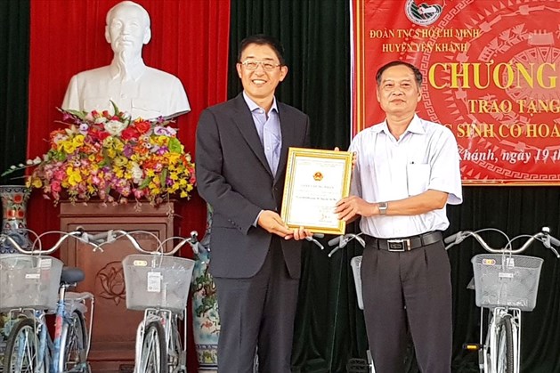 Đại diện lãnh đạo huyện Yên Khánh trao giấy chứng nhận cho Văn phòng bán vé hãng hàng không Korean Air. Ảnh: NT