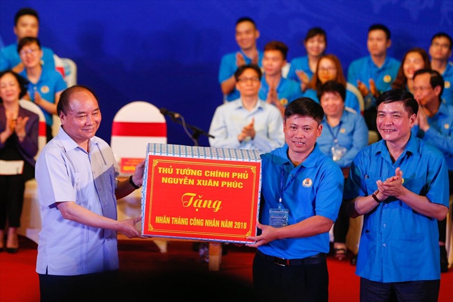 Thủ tướng Chính phủ Nguyễn Xuân Phúc và Chủ tịch TLĐLĐVN tặng bộ máy vi tính cho công nhân Vũ Xuân Đạt.