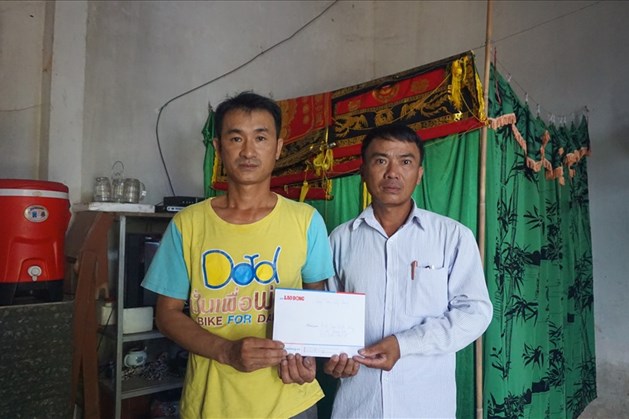 Đại diện UBND xã Quang Lộc trao quà của bạn đọc cho anh Trần Đình Dương. Ảnh: Q.Đại