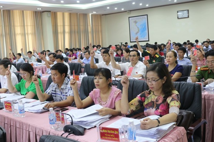 Các đại biểu HĐND tỉnh Lào Cai biểu quyết thông qua Nghị quyết sáp nhập 2 Sở. Ảnh: Báo Lào Cai