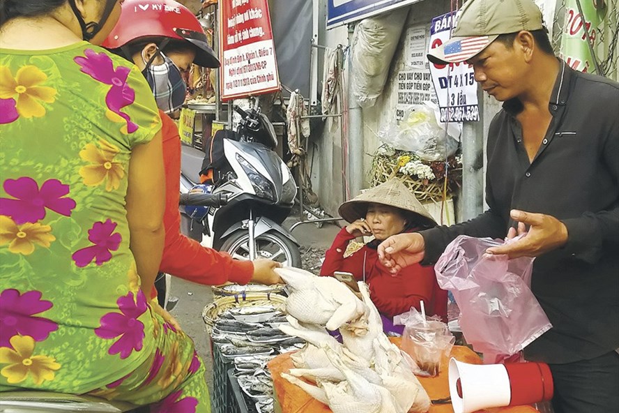 Người dân mua gà không đầu tại chợ tự phát bên hông chợ Bình Triệu (quận Thủ Đức, TPHCM). Ảnh: MINH QUÂN