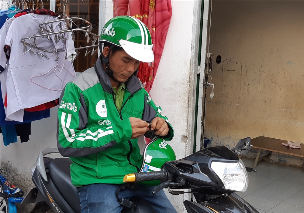 Nhiều CN sau giờ làm việc ở doanh nghiệp phải chạy Grab để có thêm thu nhập. Ảnh Nam Dương