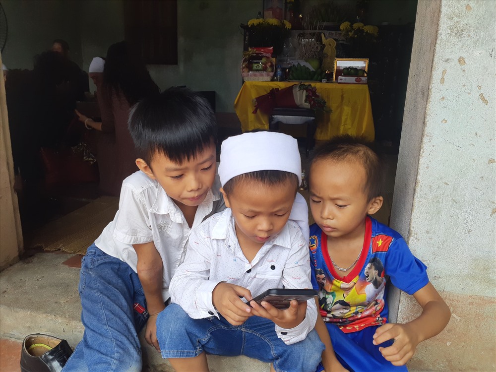 Đứa con út của anh Soái còn quá nhỏ, đầu đội khăn tang nhưng vẫn còn ham chơi, chưa hiểu hết nỗi đau mất cha. Ảnh: Thùy Linh