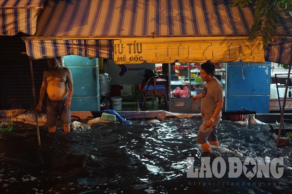 Nhưng tấm gỗ, bao cát chắn nước tạm thời chờ triều cường rút. Ảnh Tú Hà.