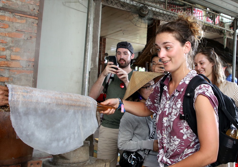 Nữ du khách người nước ngoài thích thú khi cầm trên tay bánh tráng vừa ra lò.