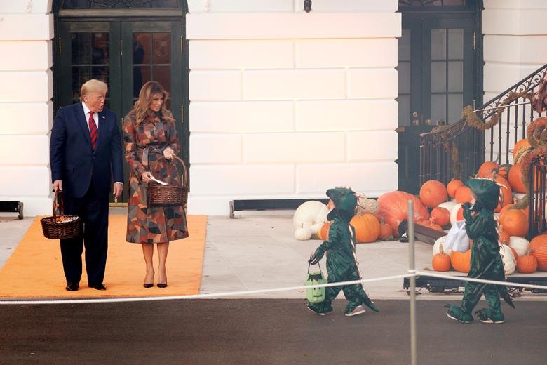 Tổng thống Mỹ Donald Trump và Đệ nhất phu nhân phát kẹo tiếp đãi các vị khách “nhí“. Ảnh: Reuters