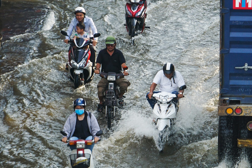 Người dân TP.Hồ Chí Minh chật vật di chuyển vì triều cường gây ngập. Ảnh: Hà Phương