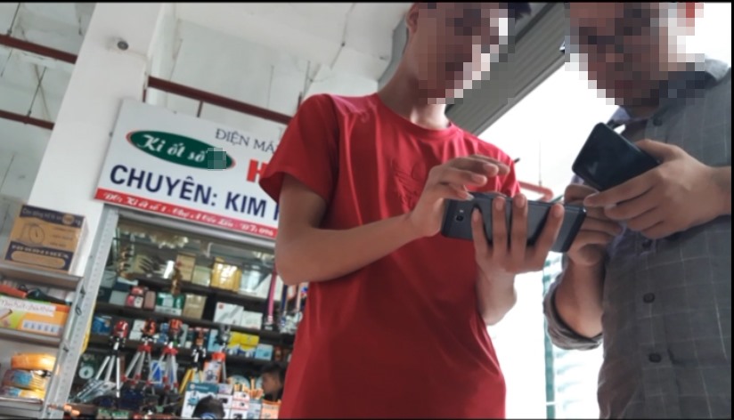 Thanh niên bán hàng tại chợ Cốc Lếu đang nhiệt tình tư vấn súng bắn đạn chì cho khách. Ảnh PV.