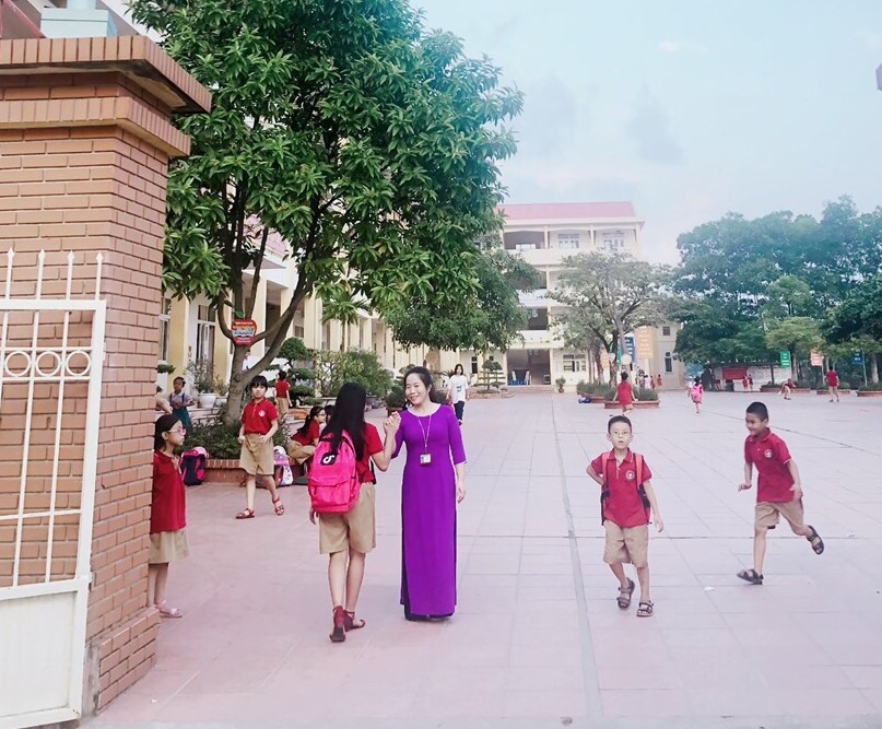Lãnh đạo ban giám hiệu đón học sinh tại cổng trường. Ảnh: BT