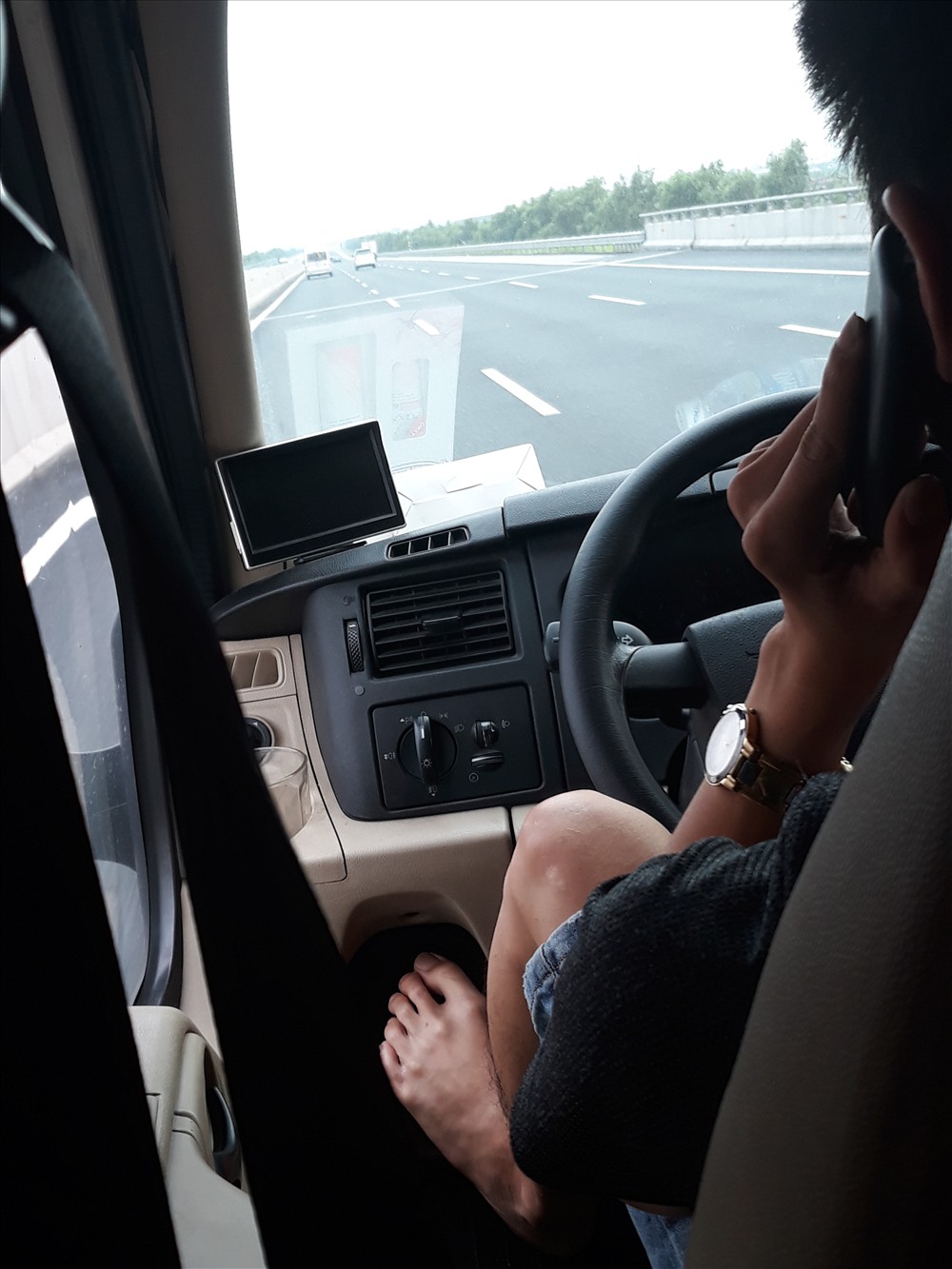 Lái xe gác chân nghe điện thoại trên xe
