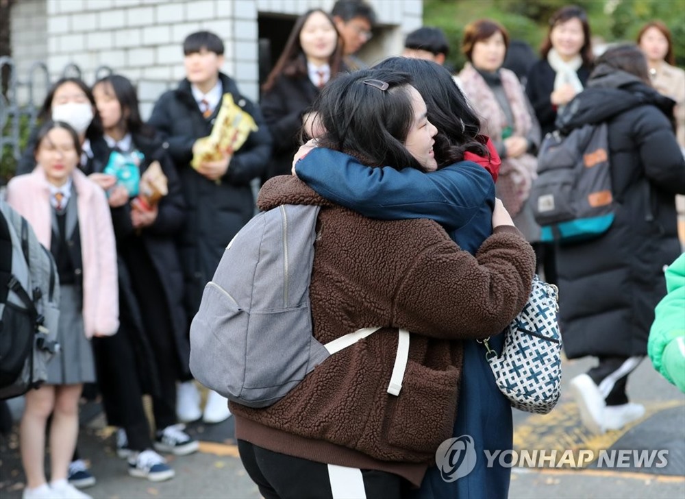 Phụ huynh động viên con trước khi vào phòng thi ở Busan. Ảnh: Yonhap.