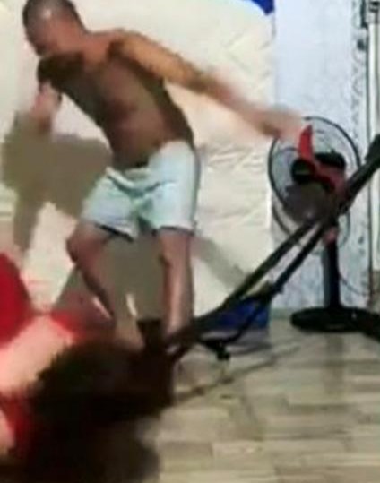 Người đàn ông xăm trổ đạp người phụ nữ xuống nền nhà.