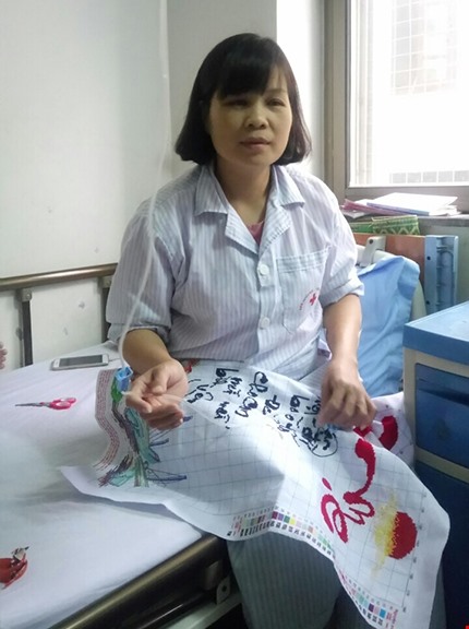 Chị Nụ tranh thủ thời gian nằm viện thêu tranh để có thêm thu nhập. Ảnh: NVCC.