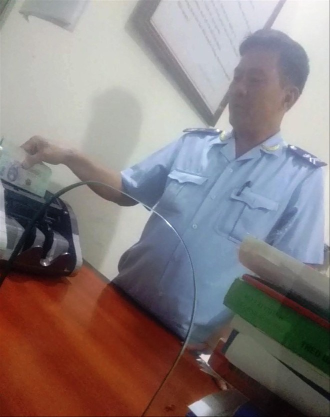 Hình ảnh ông Huyền nghi nhận tiền luật. Ảnh cắt từ clip của Báo Tiền Phong